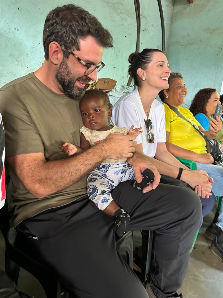 Pedro Ivo Moraes com um bebê no colo, no campo de refugiados de Dzaleka